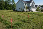 An empty building plot beside a finished house — buying land vs buying a house